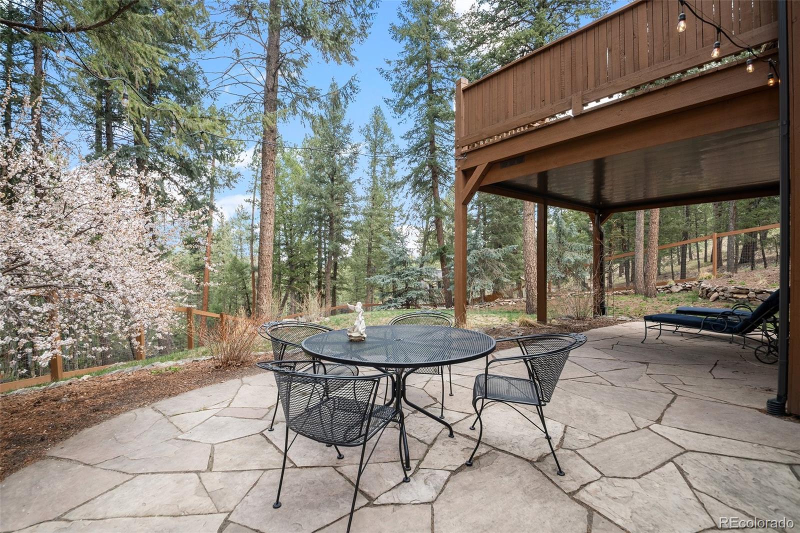 27711 Moffat Road Evergreen, CO 80439 - Photo 24 of 30 a view of a patio with a table and chairs under an umbrella