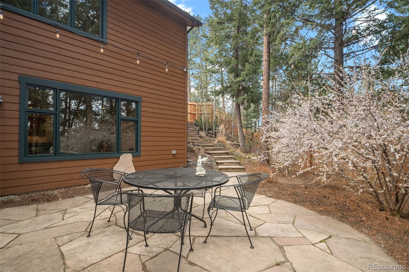 27711 Moffat Road Evergreen, CO 80439 - Photo 25 of 30 a view of a patio with table and chairs with wooden fence and plants