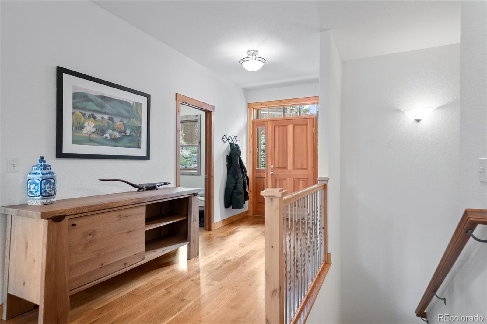27711 Moffat Road Evergreen, CO 80439 - Photo 6 of 30 a view of a hallway to rooms and wooden floor