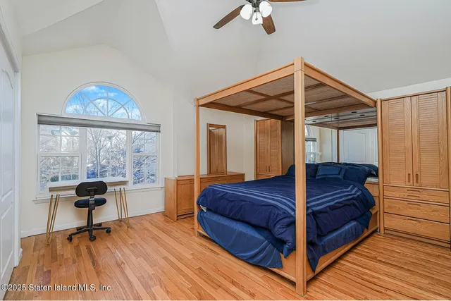 a bedroom with a bed and a large window