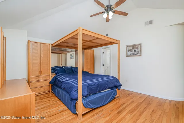 a bedroom with a bed and a ceiling fan
