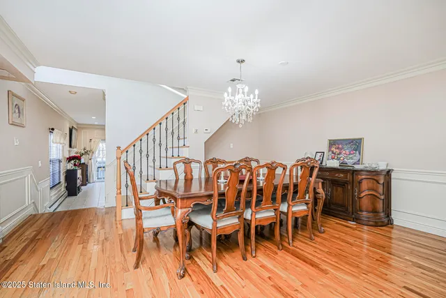 a dining room with furniture wooden floor clock and a chandelier