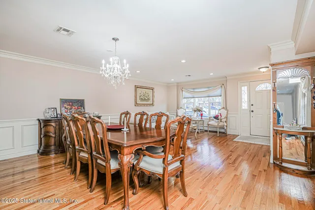 a dining room with furniture a chandelier and wooden floor