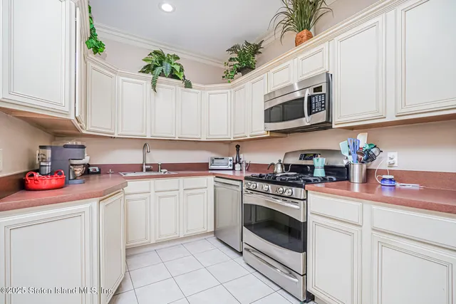 a kitchen with stainless steel appliances granite countertop white cabinets a stove a sink and dishwasher