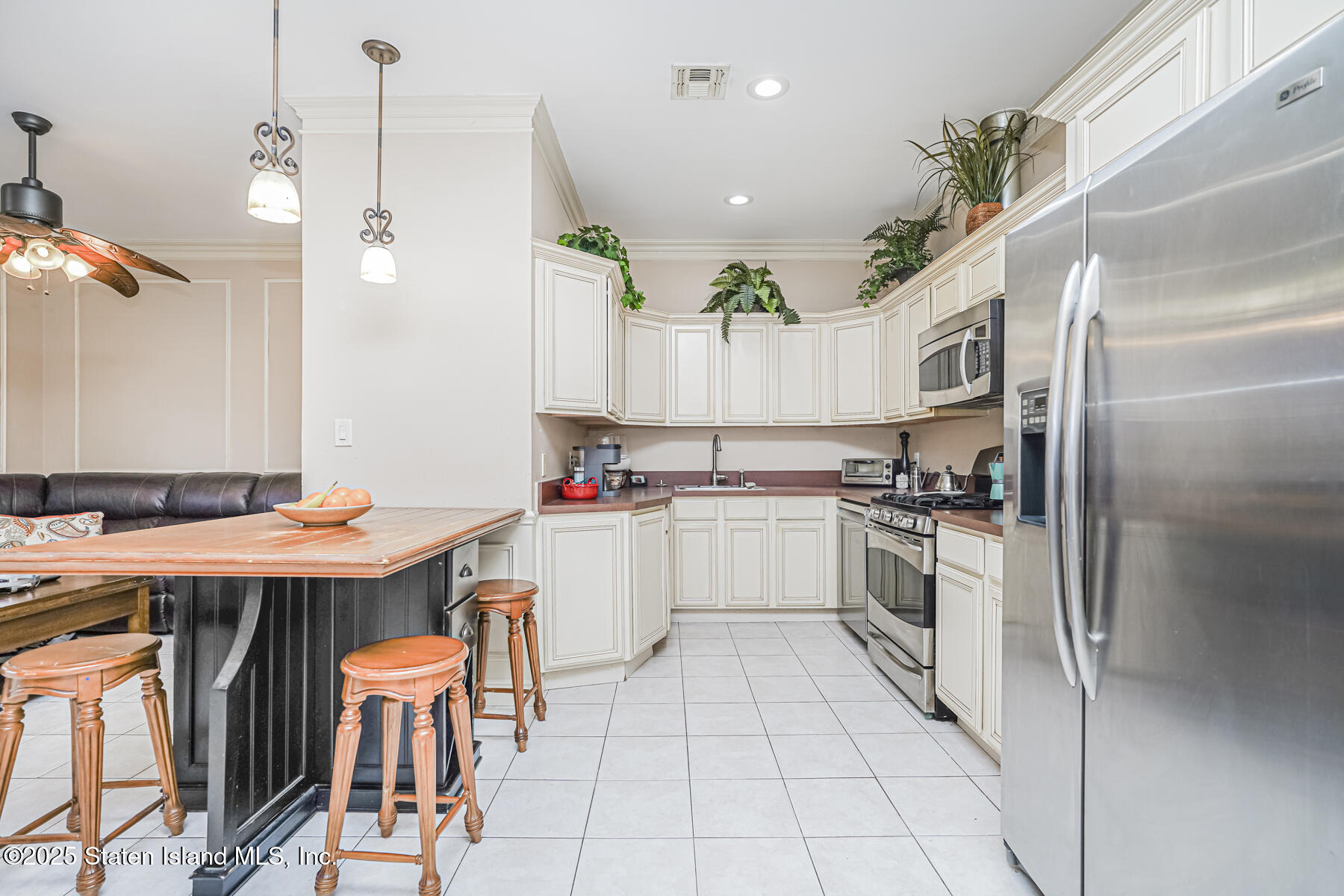 22 El Camino Loop Staten Island, NY 10309 - Photo 9 of 29 a kitchen with stainless steel appliances kitchen island granite countertop a table chairs and a refrigerator