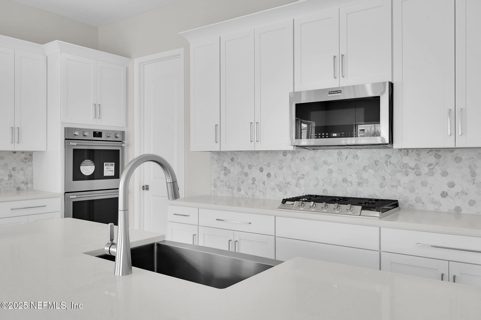 323 Sawgrass Drive Yulee, FL 32097 - Photo 22 of 48 a kitchen with granite countertop white cabinets and stainless steel appliances