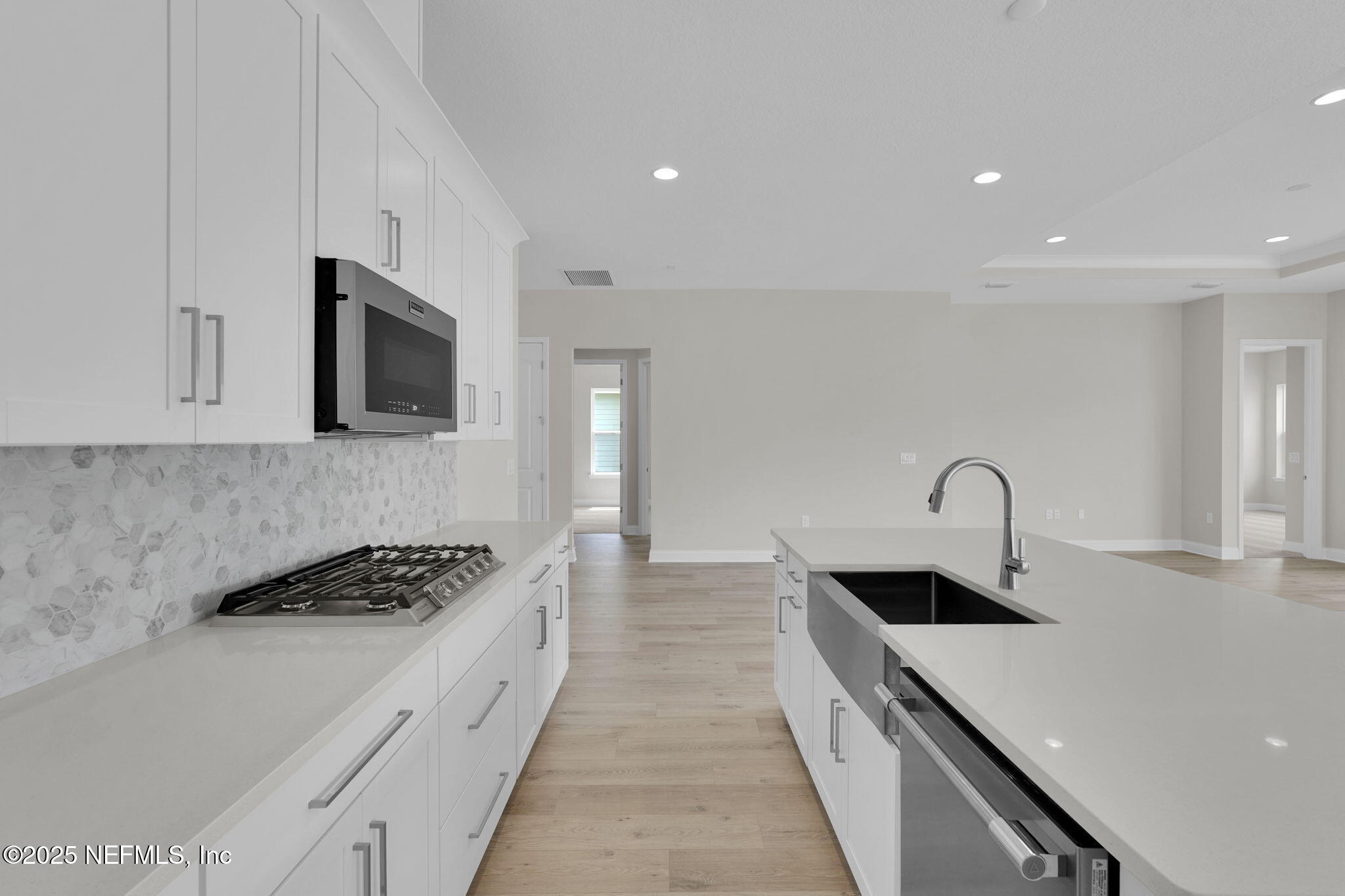 323 Sawgrass Drive Yulee, FL 32097 - Photo 23 of 48 a kitchen with stainless steel appliances kitchen island a white stove top oven and wooden floor