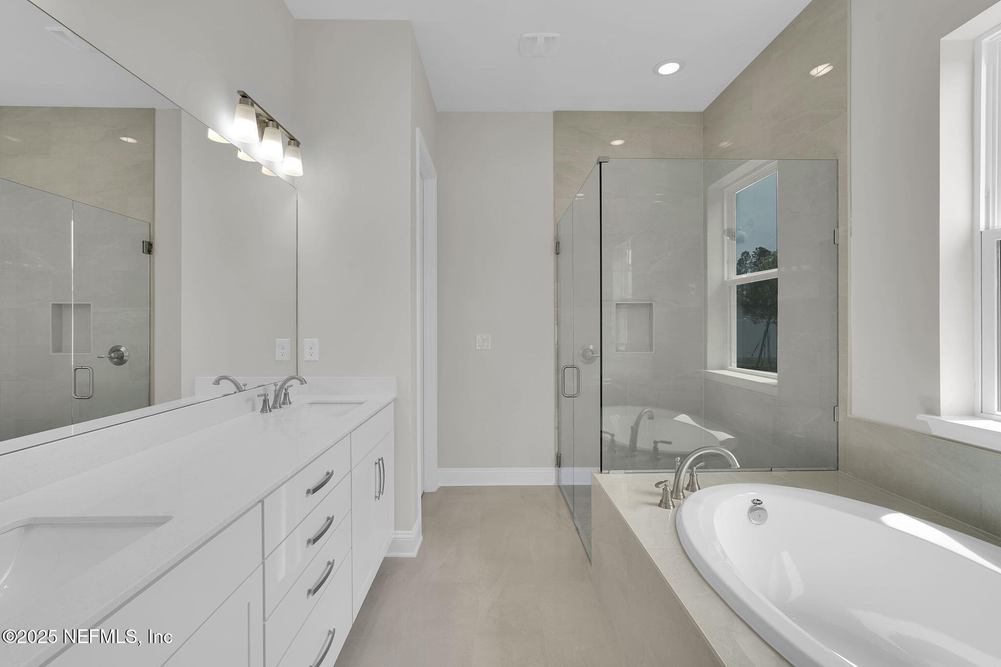 323 Sawgrass Drive Yulee, FL 32097 - Photo 28 of 48 a spacious bathroom with double vanity sinks a large mirror and a bathtub
