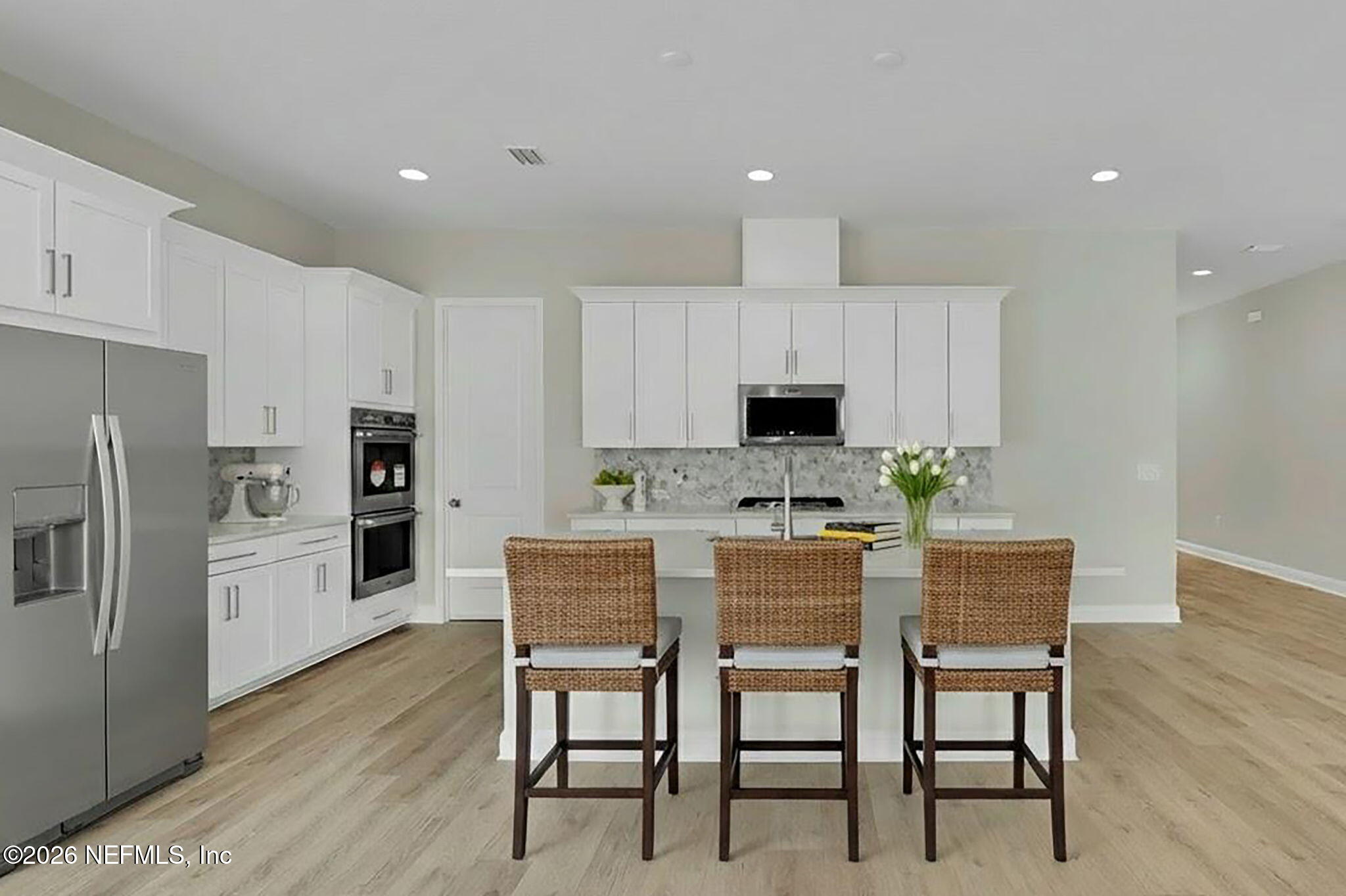 323 Sawgrass Drive Yulee, FL 32097 - Photo 6 of 48 a kitchen with kitchen island white cabinets and stainless steel appliances