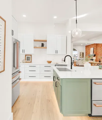 a kitchen with stainless steel appliances a sink and a refrigerator