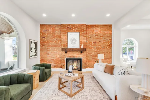 a living room with furniture a fireplace and a large window