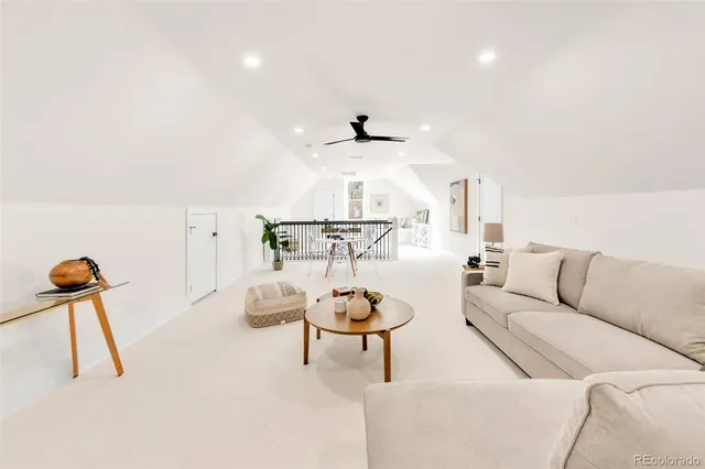 a living room with furniture and a ceiling fan