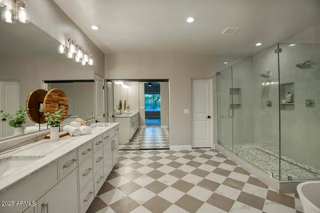 a spacious bathroom with a double vanity sink mirror and shower