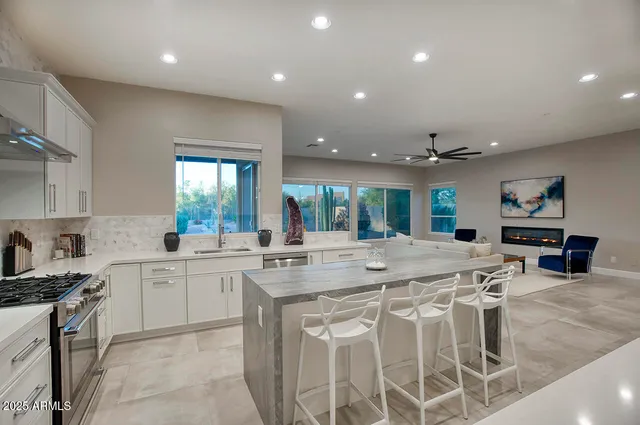 a large kitchen with kitchen island a sink table and chairs