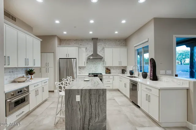 a large kitchen with stainless steel appliances lots of counter space sink and cabinets