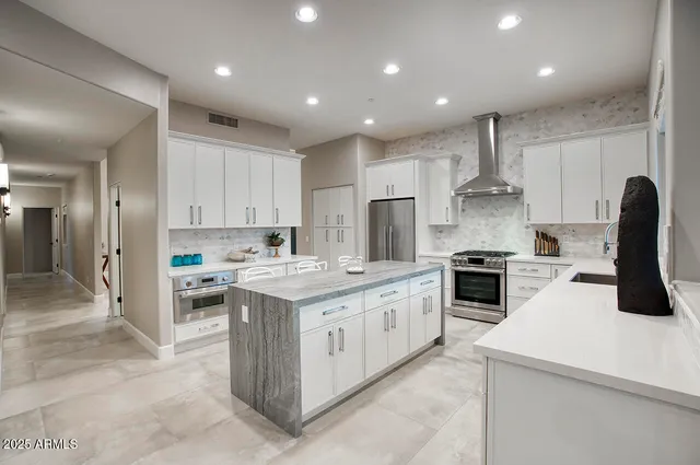 a kitchen with white cabinets and stainless steel appliances