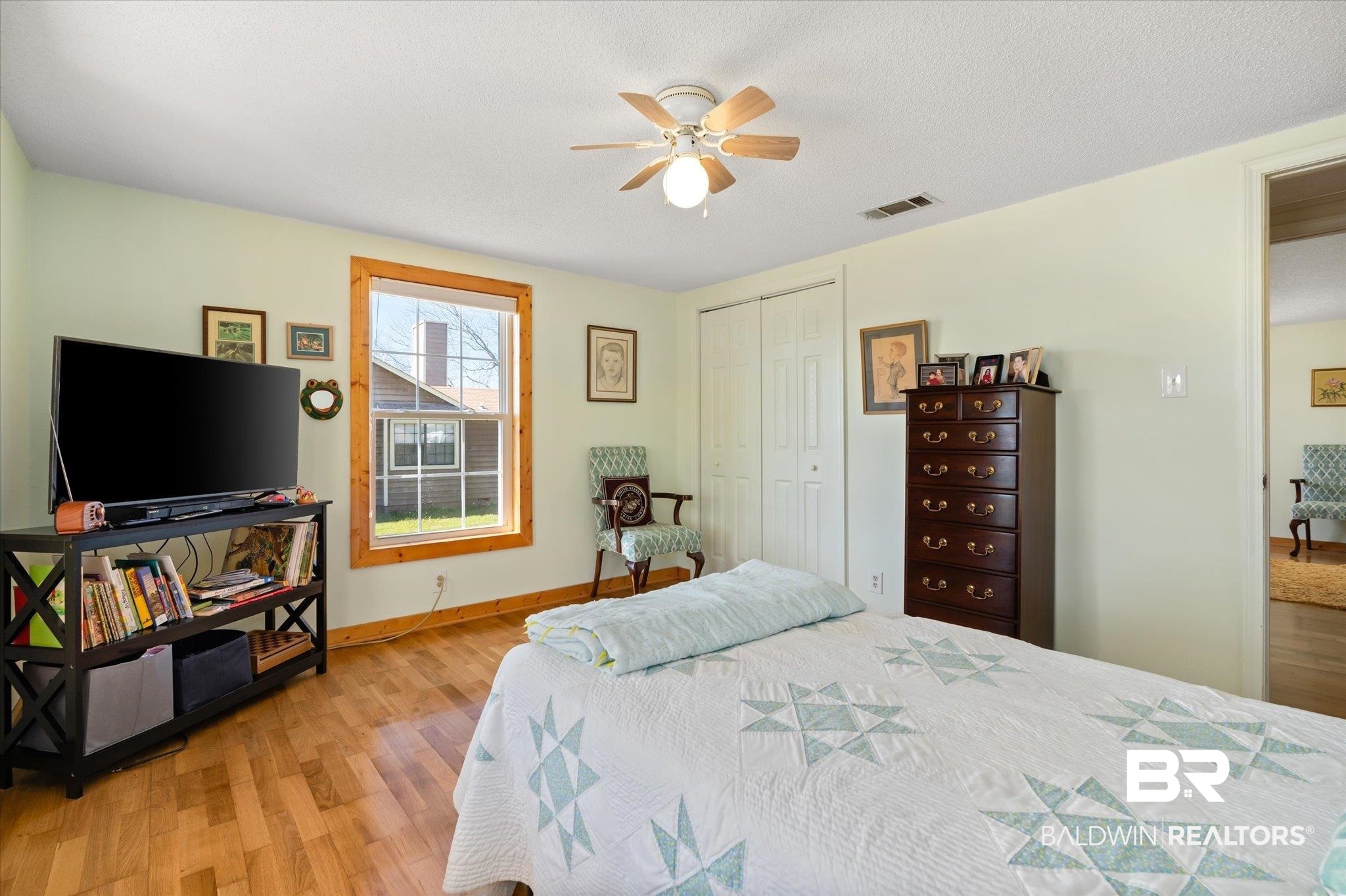 14280 Cat Deakle Road Grand Bay, AL 36541 - Photo 19 of 51 Bedroom with ceiling fan, wood finished floors, visible vents, baseboards, and a closet