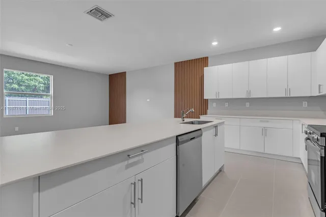 a large kitchen with cabinets and stainless steel appliances