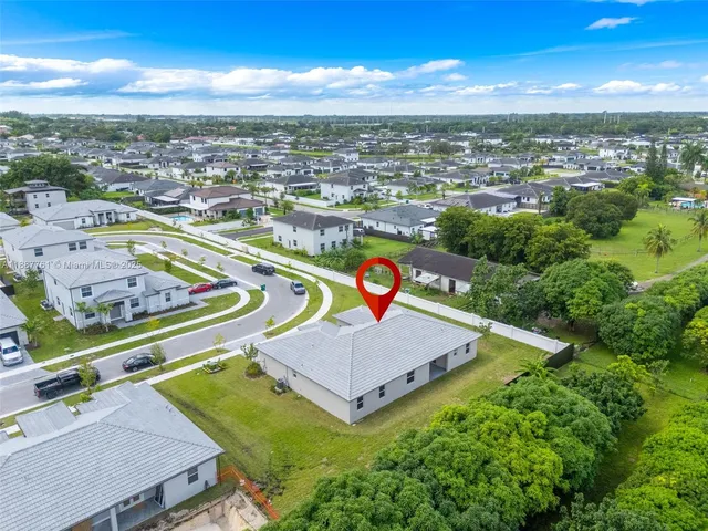 an aerial view of residential houses with outdoor space and ocean view