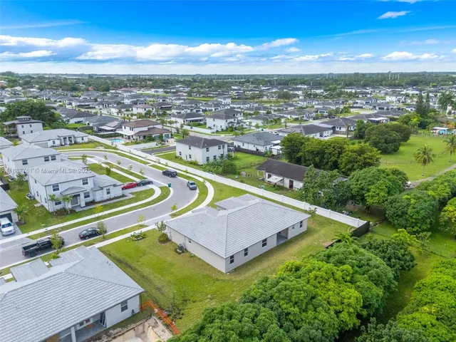 an aerial view of residential houses with outdoor space and swimming pool