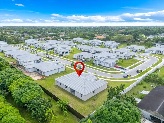 an aerial view of residential houses with outdoor space and swimming pool