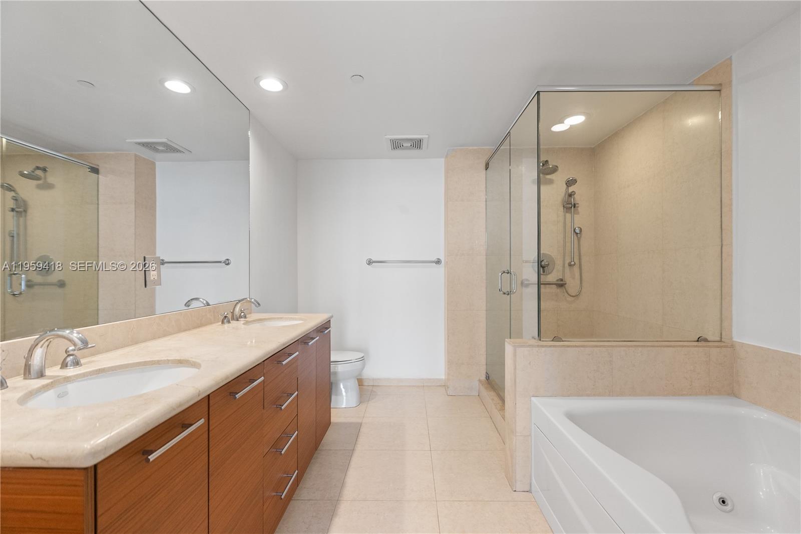50 Biscayne Boulevard, Unit 3010 Miami, FL 33132 - Photo 22 of 50 a bathroom with a granite countertop sink a mirror a bathtub and shower