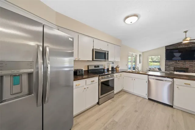 a kitchen with a sink stainless steel appliances and white cabinets