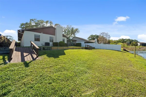 a view of a house with a big yard plants and large trees
