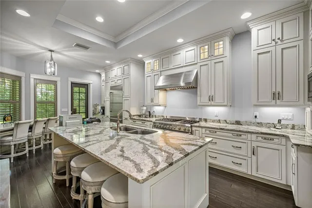 a kitchen with center island white cabinets and refrigerator