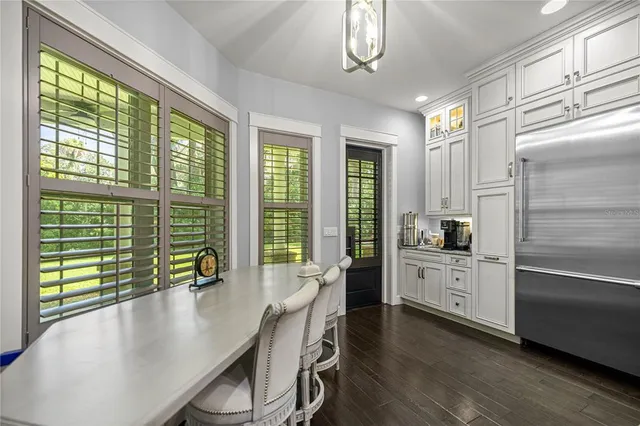 a large kitchen with kitchen island a large window cabinets a sink and stainless steel appliances