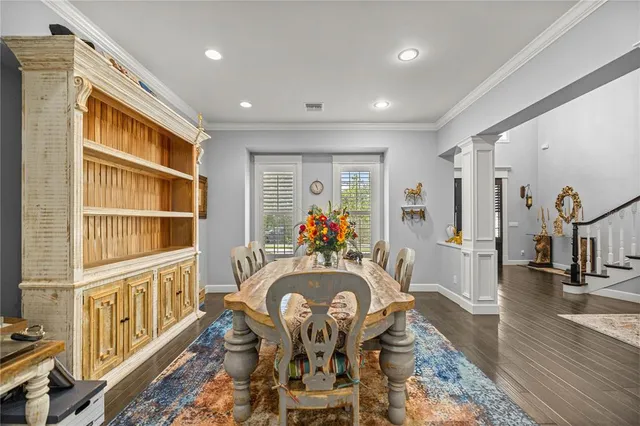 a view of a dining room with furniture a rug and wooden floor