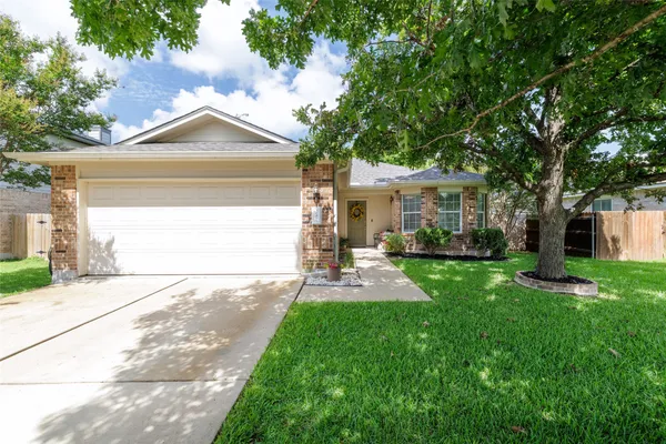 a front view of a house with a yard and a garage