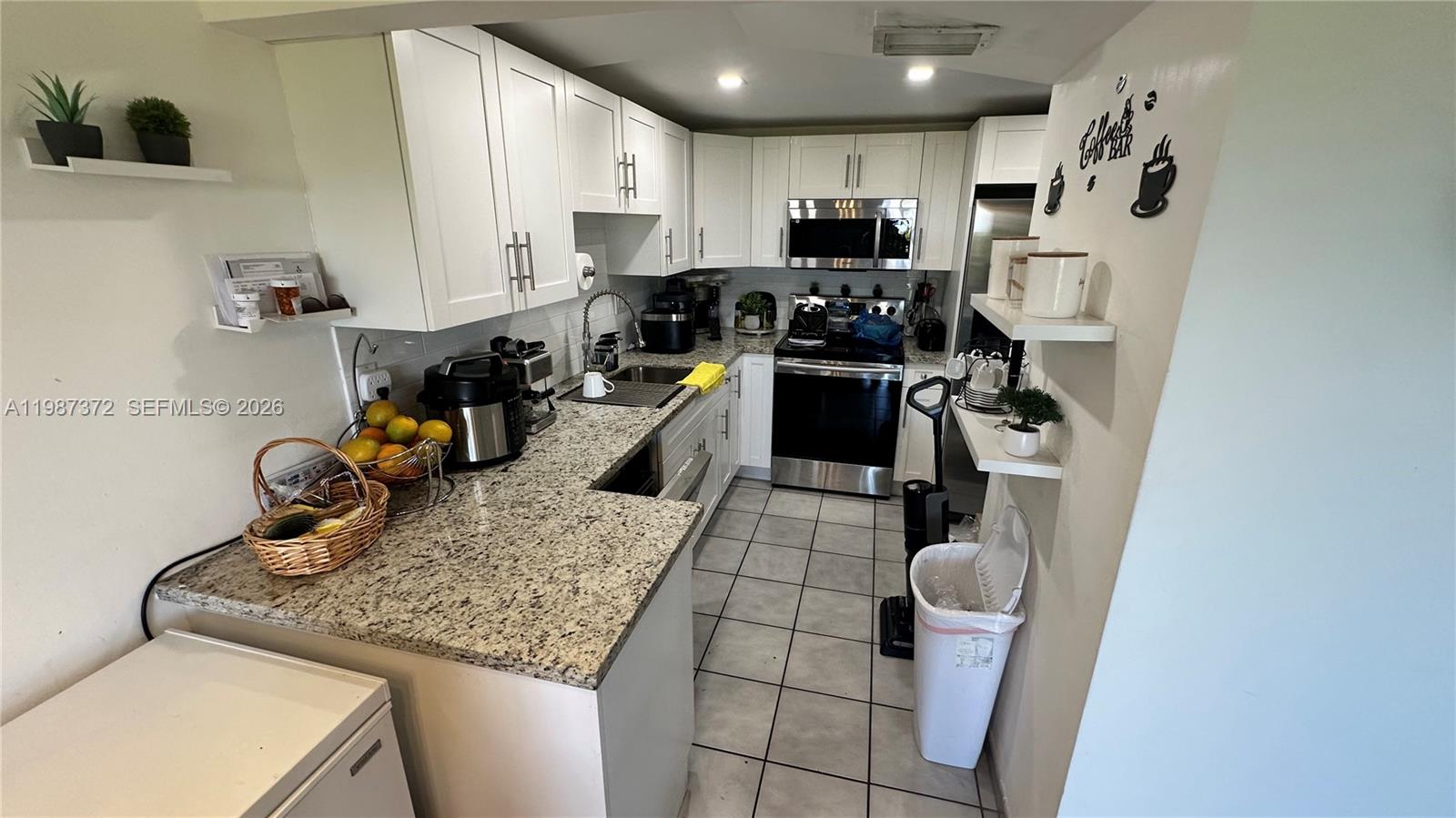 14250 Southwest 62nd Street, Unit 517 Miami, FL 33183 - Photo 18 of 47 a kitchen with sink refrigerator and stove