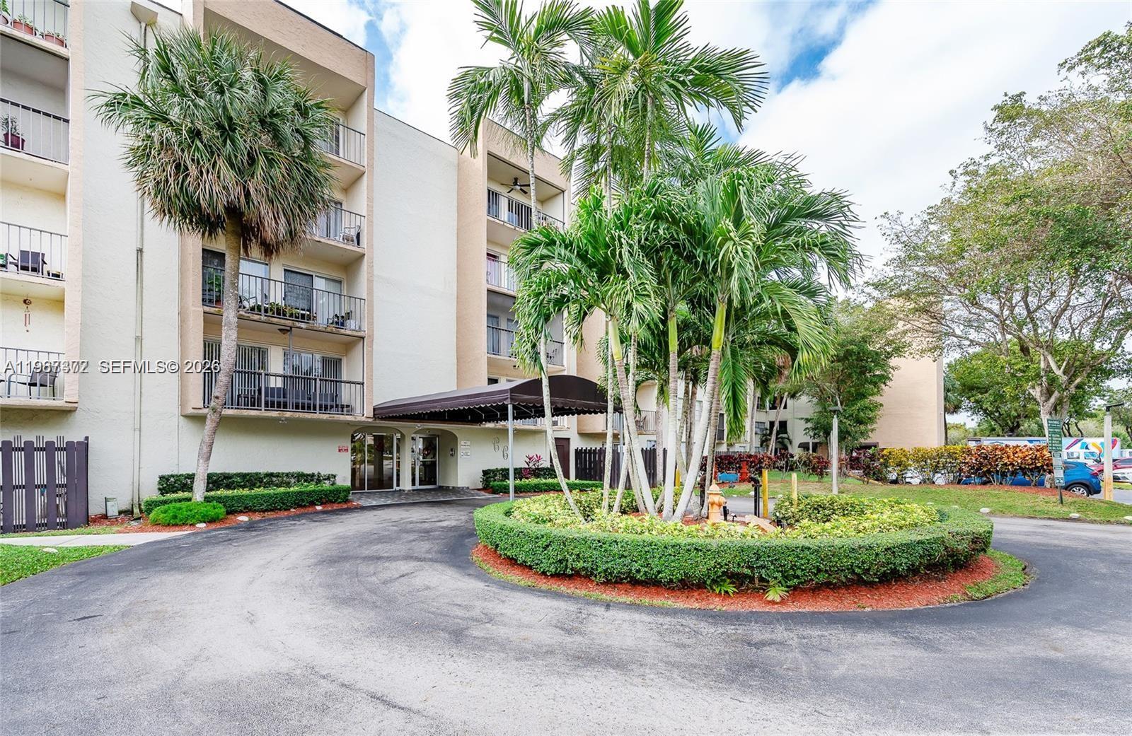 14250 Southwest 62nd Street, Unit 517 Miami, FL 33183 - Photo 4 of 47 a front view of a house with a garden and palm trees