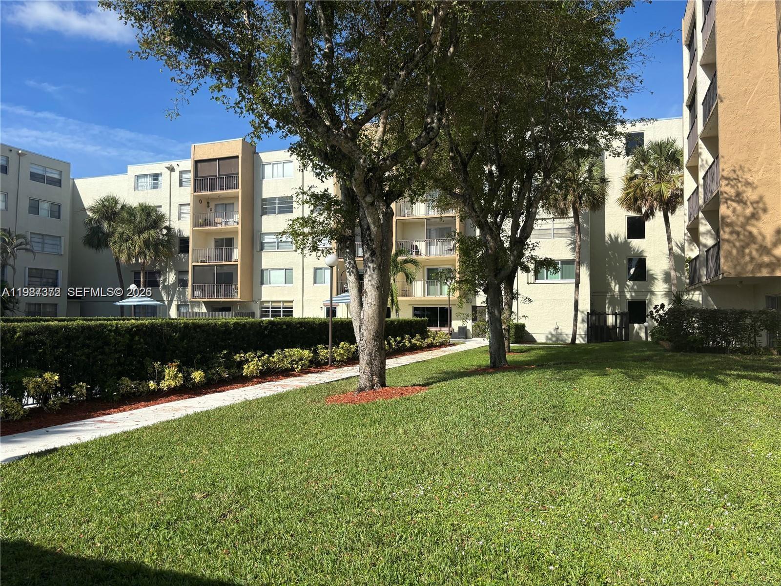 14250 Southwest 62nd Street, Unit 517 Miami, FL 33183 - Photo 43 of 47 a view of a building with a yard