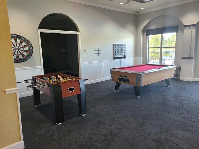 a room with pool table and windows