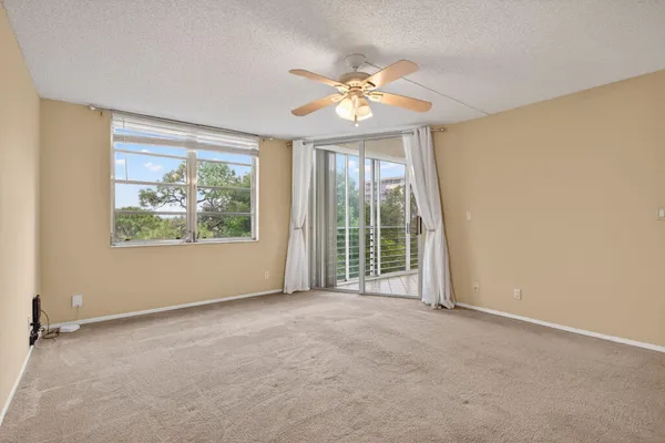 an empty room with windows and fan
