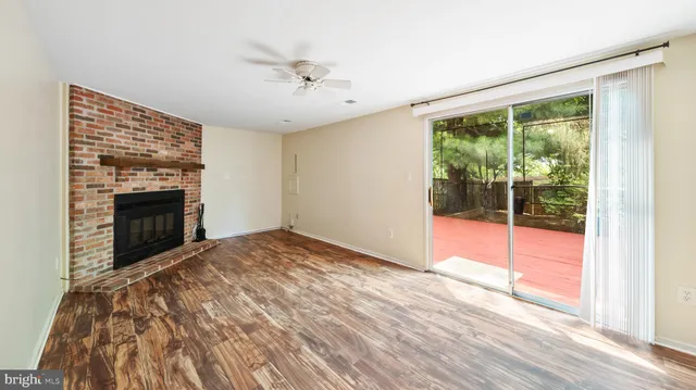a view of empty room with wooden floor and fireplace