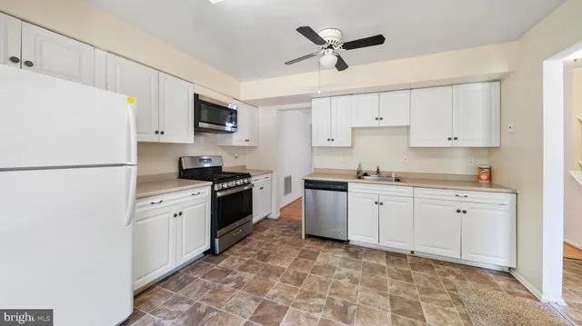 a kitchen with granite countertop cabinets stainless steel appliances and a sink