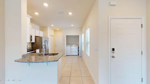 a view of a hallway to a room with kitchen
