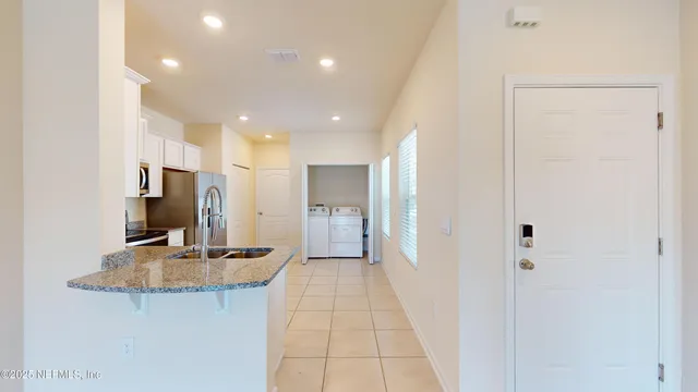 a view of a hallway to a room with kitchen