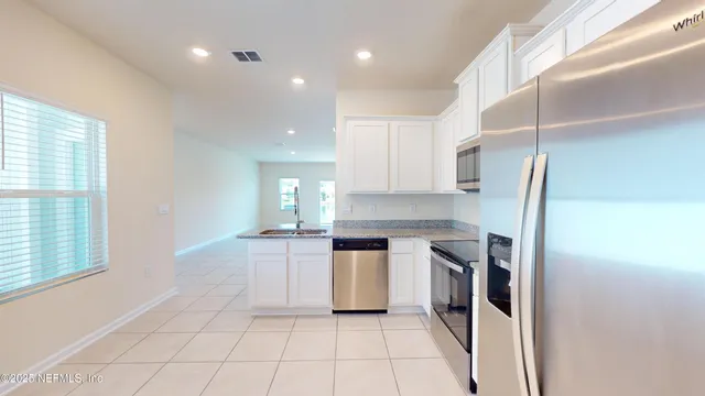 a kitchen with a sink a counter top space stainless steel appliances and cabinets
