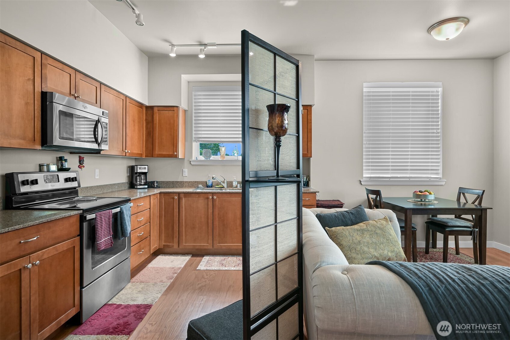 8844 Depot Road, Unit B101 Lynden, WA 98264 - Photo 10 of 30 a kitchen with stainless steel appliances granite countertop a refrigerator a stove a sink a dining table and chairs