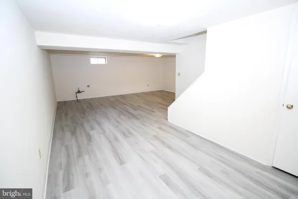 a view of a room with wooden floor and white walls