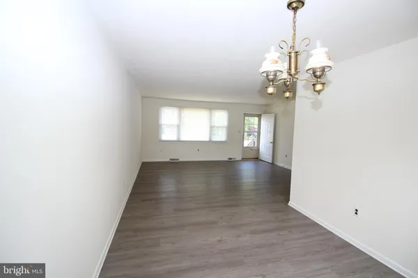 a view of a livingroom with wooden floor and a chandelier
