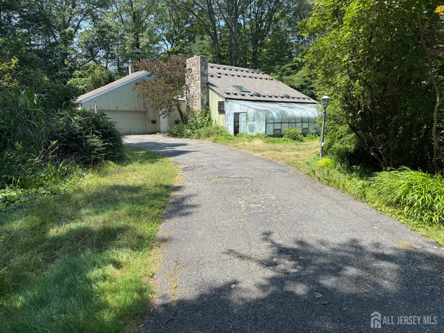a front view of a house with a garden and trees