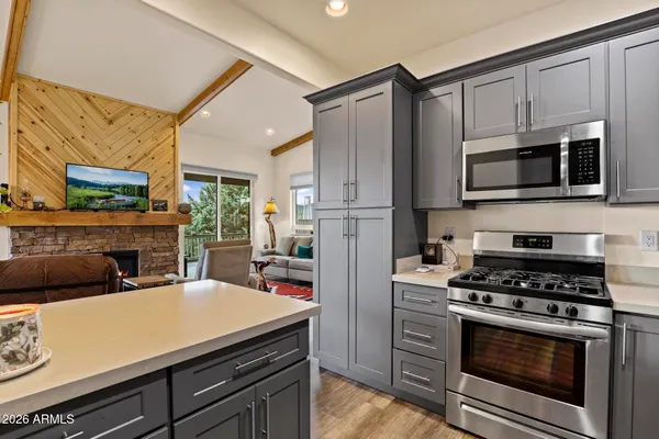 a kitchen with cabinets stainless steel appliances and wooden floor