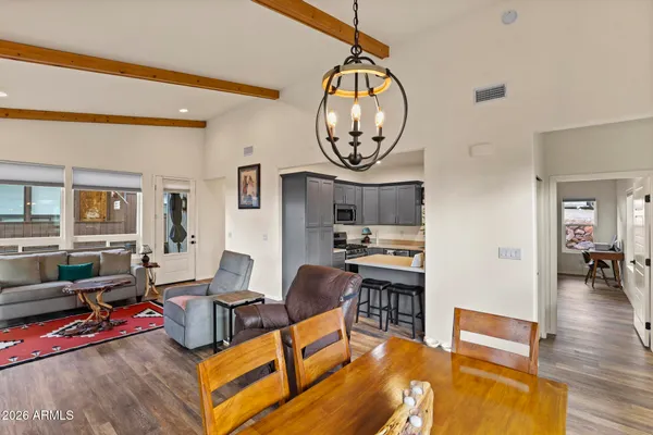 a living room with furniture a dining table and chairs with wooden floor