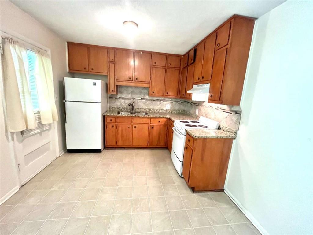 1002 Level Creek Road, Unit 201 Sugar Hill, GA 30518 - Photo 7 of 13 a kitchen with stainless steel appliances granite countertop a refrigerator a sink a stove a microwave and island