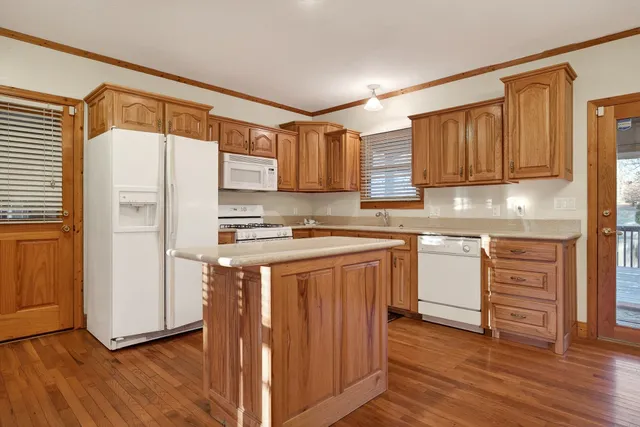 a view of an empty room with window and chandelier fan